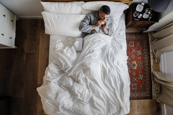 Άρρωστος Άνθρωπος Στο Κρεβάτι Φυσάει Μύτη Του — Φωτογραφία Αρχείου