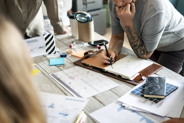 Tattooed woman planning at table