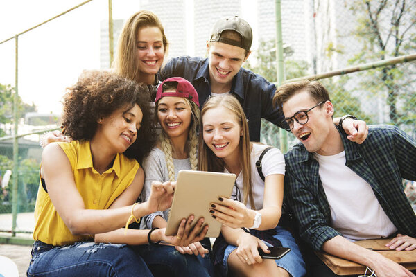 Friends in the park using a digital tablet, millennial and youth culture concept