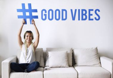 Kadın bir kelime tutan bir kanepede: iyi vibes