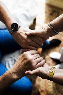 Kıdemli çift el ele tutuşuyor.