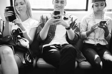 Akıllı telefonlar metroda kullanarak genç yetişkin arkadaş grubu