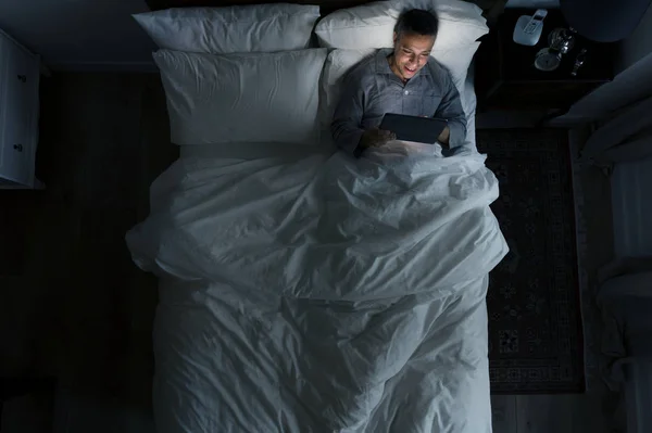 Man Bed Met Zijn Tablet — Stockfoto