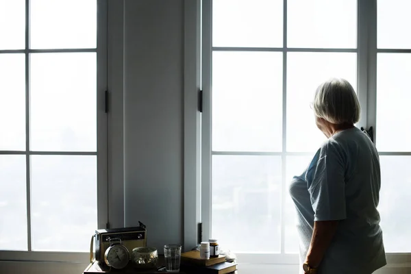 Senior Woman Standing Alone Looking Window Home — Stock Photo, Image