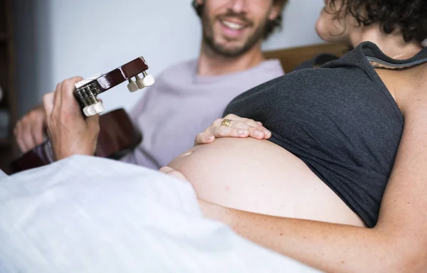 Homem Tocando Guitarra Para Esposa Grávida Cama — Fotografia de Stock