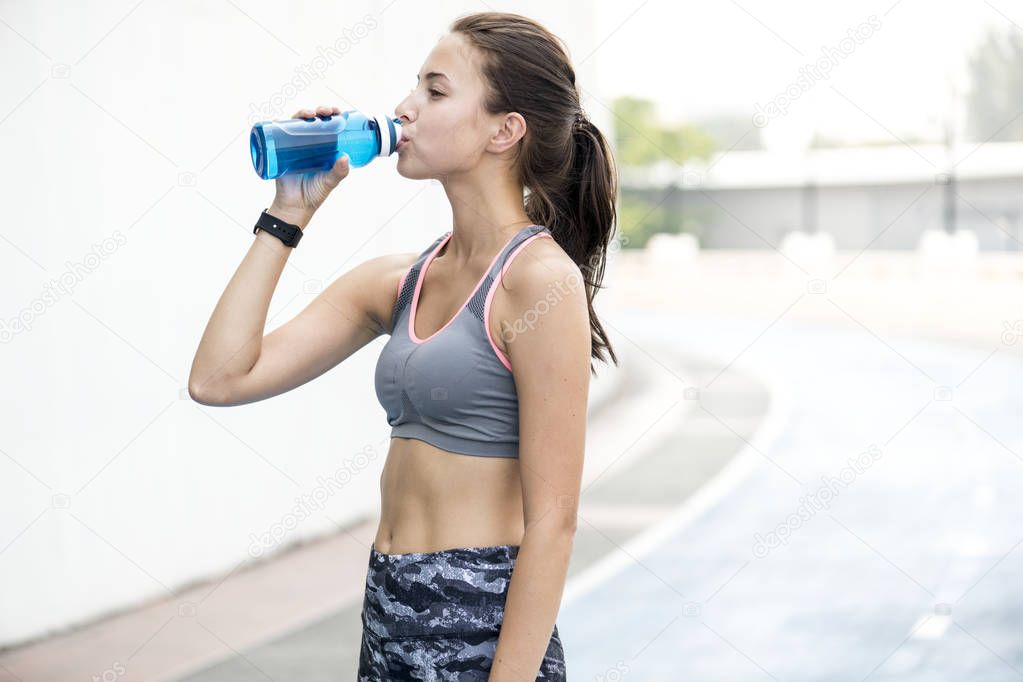 Active woman drinking water 