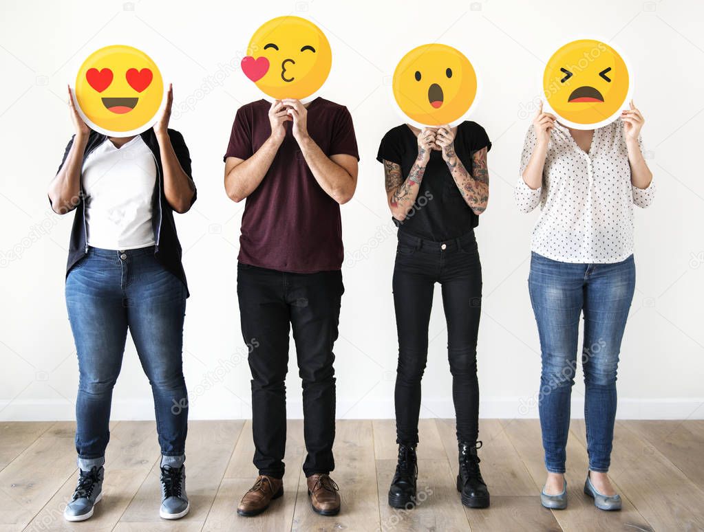 Diverse people holding emoticon