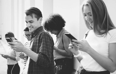 Arkadaşlar açık havada birlikte akıllı telefonlar kullanan ve soğutma