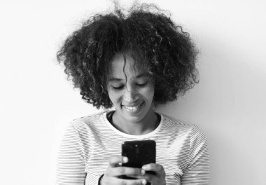 Gülümseyen kadın bir akıllı telefon, siyah ve beyaz kullanma