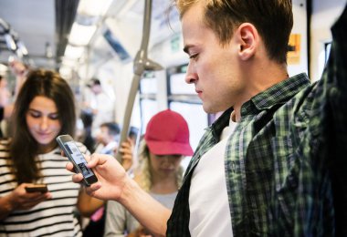 Akıllı telefonlar metroda kullanarak genç yetişkin arkadaş grubu