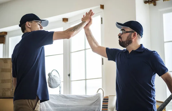 Two men renovating the house, giving high five