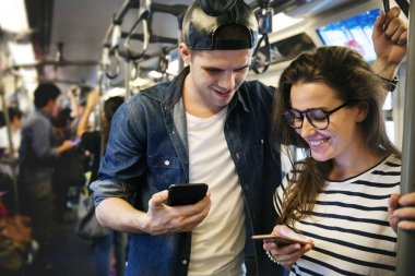 Şirin çift akıllı telefonlar metroda kullanarak
