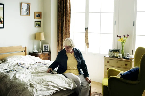 Старшая Женщина Смотрит Семейное Фото Спальне — стоковое фото