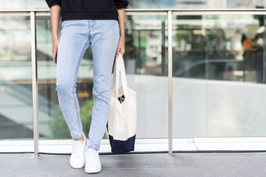 Şehirde alışveriş çantası tutan kadın düşük bölümü