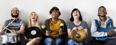 ararken, marakas, gitar, vinil kayıt ve davul ile kanepede oturan mutlu müzik grubu