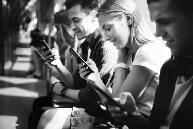 Grup genç yetişkin arkadaşlar akıllı telefonlar metro, siyah ve beyaz kullanma