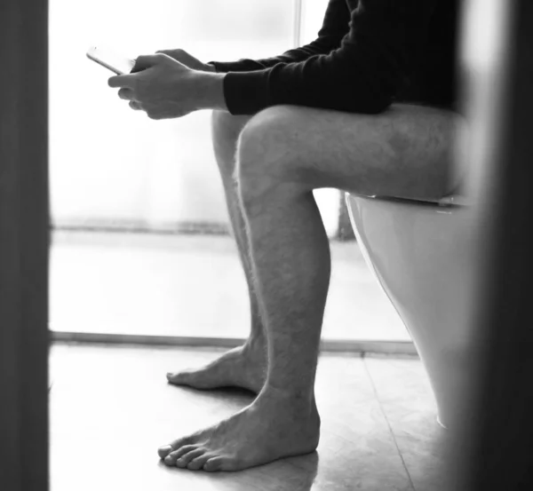 Hombre Asiento Del Inodoro Usando Teléfono Inteligente Blanco Negro — Foto de Stock