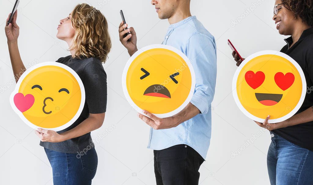 People holding emoticons using phones 
