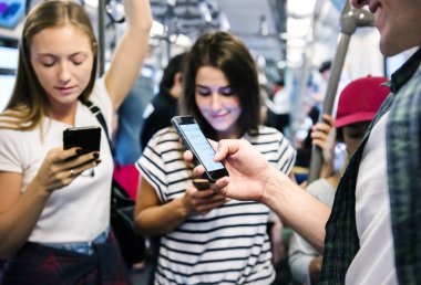 Akıllı telefonlar metroda kullanarak genç yetişkin arkadaş grubu