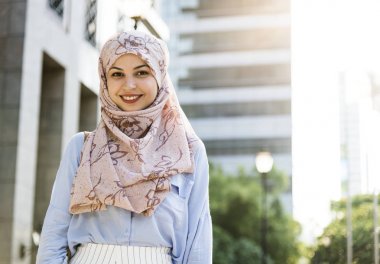 Ayakta ve şehirde gülümseyen islam kadın 