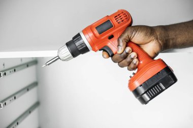 Elektronik matkap kullanan adam kabine yüklemek