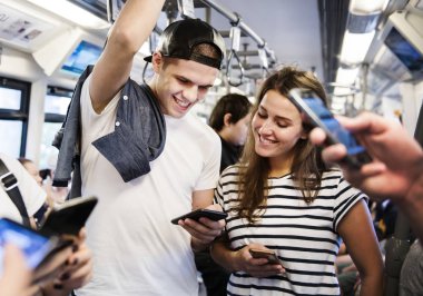 Akıllı telefonlar metroda kullanarak genç yetişkin arkadaş grubu