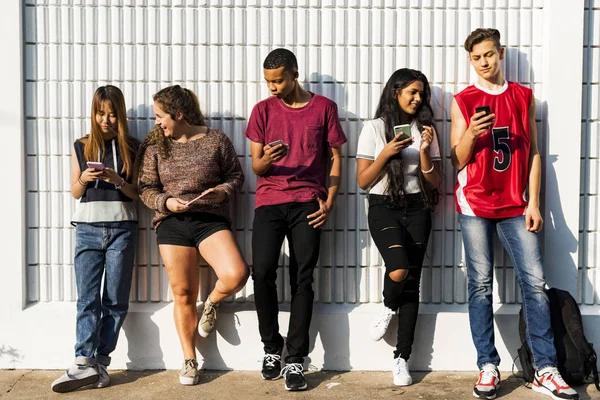 一群年轻的青少年朋友一起使用智能手机社交媒体的概念一起降温 — 图库照片