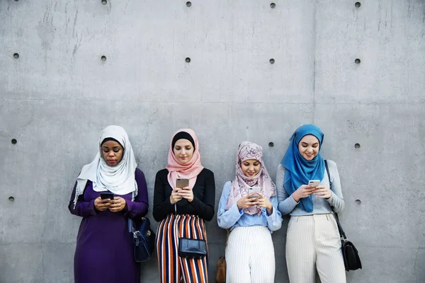 Grupa Islamskich Kobiet Pomocą Inteligentnych Telefonów Stojący Pobliżu Szare Ściany — Zdjęcie stockowe