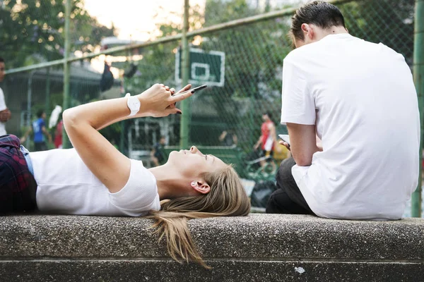 Ung Kvinna Liggande Parken Med Hjälp Smartphone — Stockfoto