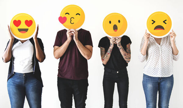 Diverse people holding emoticon