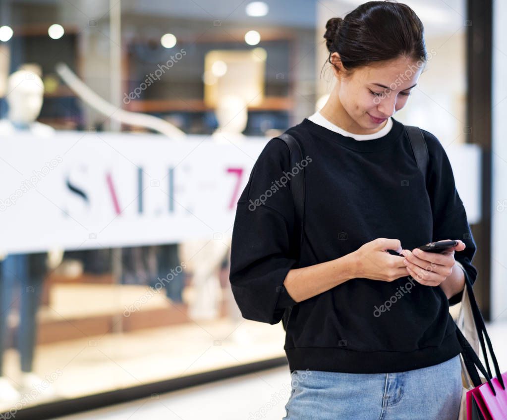 Woman enjoy shopping, using phone at mall 
