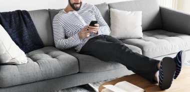 Kanepeye aygıt kullanan adam