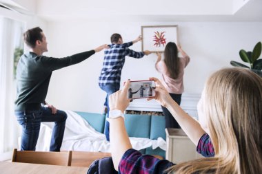 Genç grup dekorasyon daire ve fotoğraf çekme bir kadın arkadaşıyla 