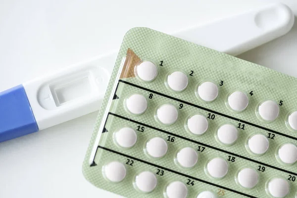 Closeup of pregnancy test and contraceptive pills, birth control concept
