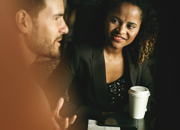 Партнеры обсуждают бизнес за кофе
