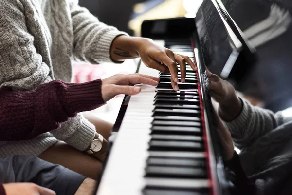 Couple praticing on a piano together