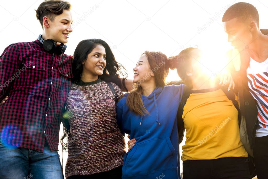 Group of school friends outdoors arms around one another togetherness and community concept