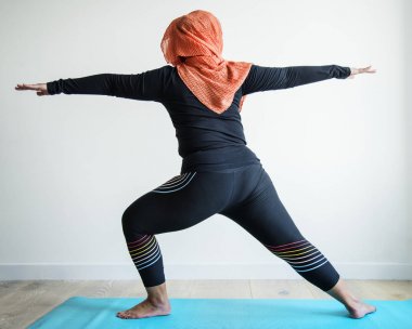 Islamic woman doing yoga in the room  clipart