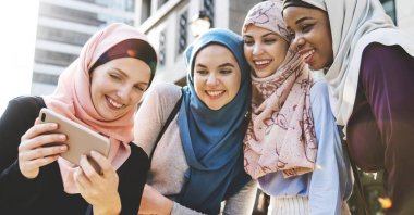 Group of islamic women looking at smartphone  clipart