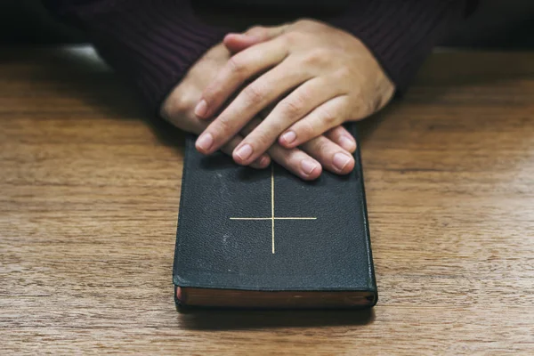 Χέρια Πάνω Από Την Αγία Γραφή Στο Ξύλινο Τραπέζι — Φωτογραφία Αρχείου