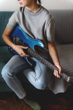 Kanepede gitar çalan kadın.