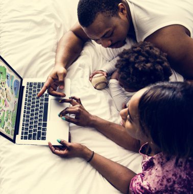 Afrika aile bilgisayar dizüstü birlikte yatak odasında kullanarak yatakta yalan