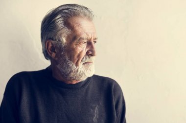 Yaşlı beyaz adam düşünceli yüz ifadesi ile yan görünüm