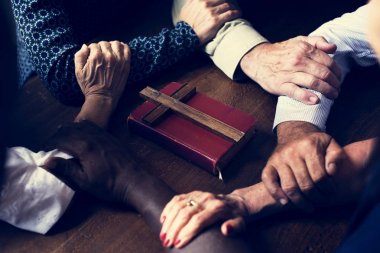 İncil'de ve tahta haç üzerinde işbirliği closeup ekip çalışması eller