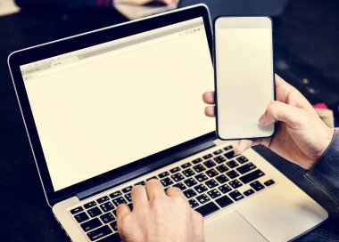 Hareket eden telefon ile bilgisayar dizüstü bilgisayar arka plan holding eller closeup