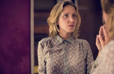 Sarışın kadın kendi yansıma bakıyor