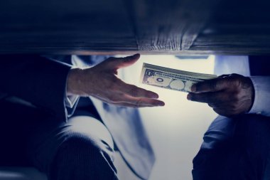 cropped image of male hands with money under table, corruption  clipart