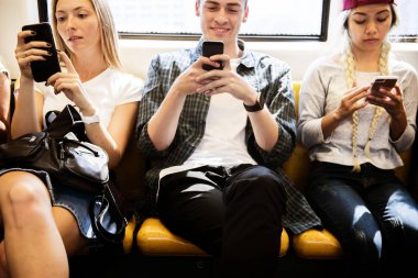 Akıllı telefonlar metroda kullanarak genç yetişkin arkadaş grubu