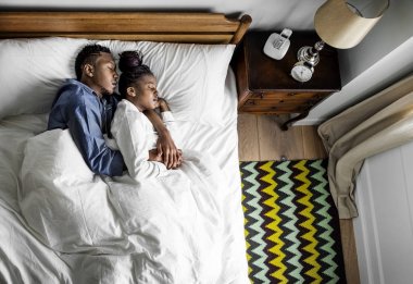 Güzel Afrikalı-Amerikalı çift yatakta snuggling