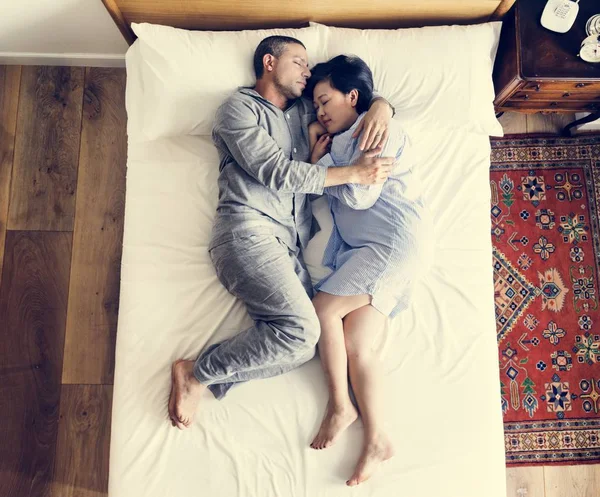 stock image Interracial couple sleeping together on the bed